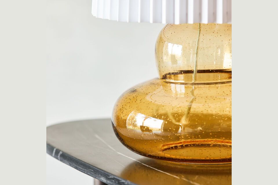 Ce luminaire sophistiqué allie harmonieusement le verre teinté d\'ambre et un abat-jour plissé